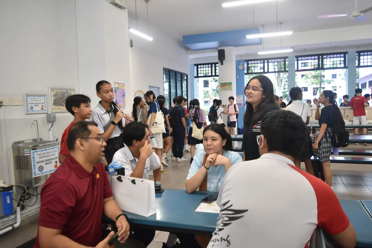 Teachers and former students talking together during a school visit