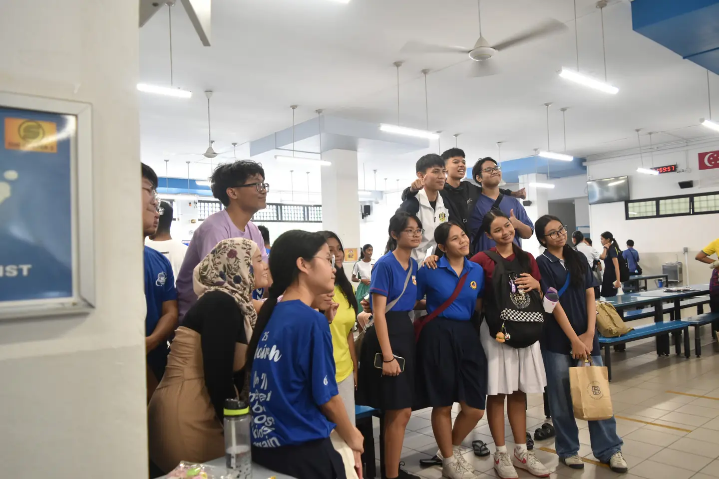 A large group of graduates gathered for a photo in the school canteen